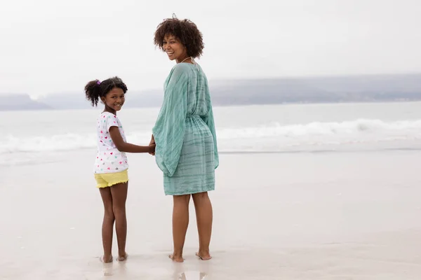 Portret Afroamerykańskiej Matki Córki Stojącej Razem Ręka Rękę Plaży — Zdjęcie stockowe