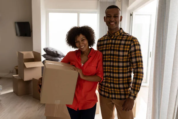 幸福的非洲裔美国人夫妇站在一起 纸板箱在家里的客厅的肖像 — 图库照片