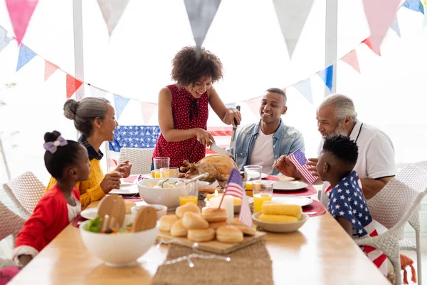 Side view of Multi-generation African American family sitting together for having meal on a dining table at home
