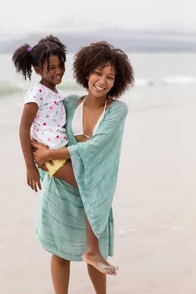 晴れた日にビーチで一緒に立っている幸せなアフリカ系アメリカ人の母と娘の正面図 — ストック写真