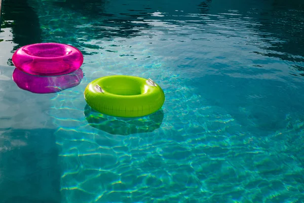 在家里后院的游泳池里漂浮着充气管子 — 图库照片