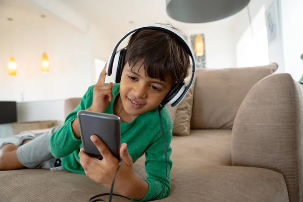 Vista Frontal Niño Americano Con Auriculares Escuchando Música Teléfono Móvil —  Fotos de Stock