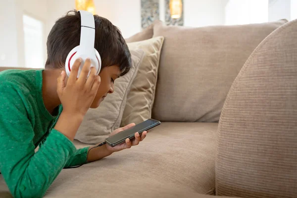 Zijaanzicht Van Amerikaanse Jongen Met Headset Luisteren Muziek Mobiele Telefoon — Stockfoto