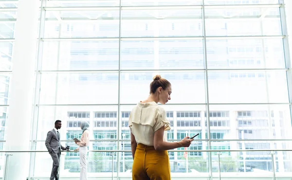 Achteraanzicht Van Jonge Vrouwelijke Executive Kijken Naar Haar Mobiele Telefoon — Stockfoto