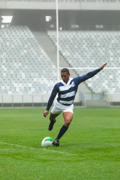 Front Visning Afrikansk Amerikansk Mandlig Rugbyspiller Sparker Rugbybold Stadion - Stock-foto