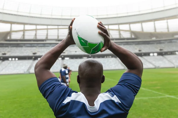 Bakifrån Afrikansk Amerikansk Manlig Rugbyspelare Kastar Rugby Bollen Stadion Med — Stockfoto