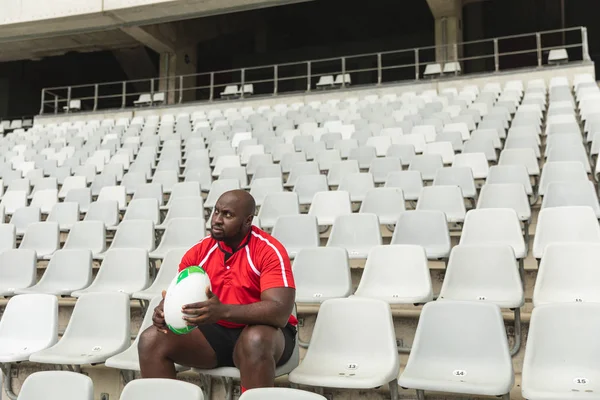 Stadyumda Rugby Topu Ile Oturan Üzgün Afro Amerikan Erkek Rugby — Stok fotoğraf