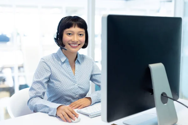オフィスのデスクでコンピュータに取り組む若い可愛いアジアの女性カスタマーサービスエグゼクティブの正面図 — ストック写真