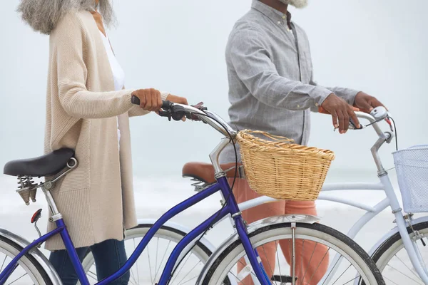 在海滩骑自行车的非洲裔美国人的侧视图特写 正宗的退休老人生活理念 — 图库照片