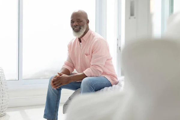 寝室のベッドに座っているアフリカ系アメリカ人男性の側面 本物のシニアリタイアライフコンセプト — ストック写真