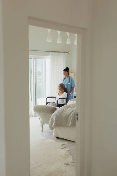 Seitenansicht Von Gesundheitshelferin Und Frau Rollstuhl Drinnen Authentisches Senioren Lebenskonzept — Stockfoto