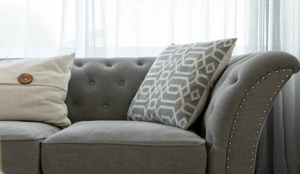 パターン化されたスロー枕が付いている灰色のソファの正面図 — ストック写真
