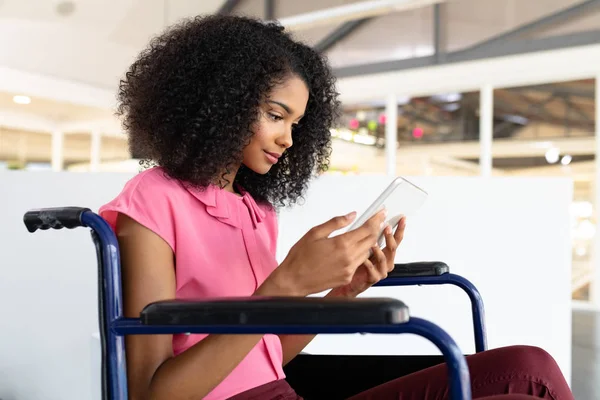 Side view of disabled African american female graphic designer using digital tablet in office.