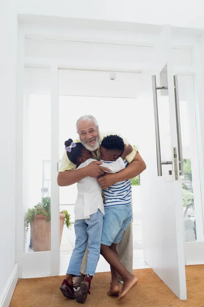 Vooraanzicht Van Afro Amerikaanse Kinderen Knuffelen Hun Grootvader Hal Thuis — Stockfoto