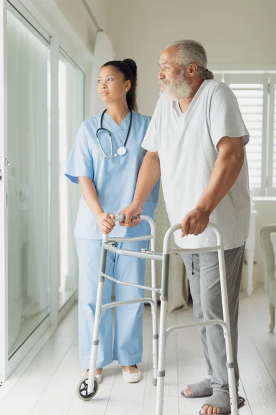 Seitenansicht Des Gesundheitspersonals Mit Mann Der Gehhilfe Innenraum Benutzt Authentisches — Stockfoto