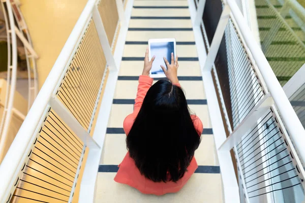漂亮的年轻亚洲女商人在办公室楼梯上使用数字平板电脑的高角度视图 — 图库照片