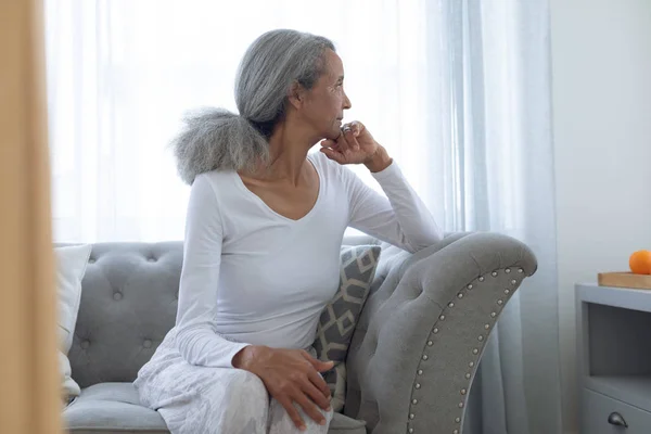 Zijaanzicht Van Doordachte Senior Gemengde Race Vrouw Zittend Bank Thuis — Stockfoto