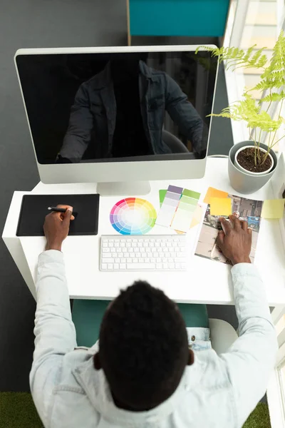 非洲裔美国男性平面设计师在办公室使用图形平板电脑的高视角图像 — 图库照片