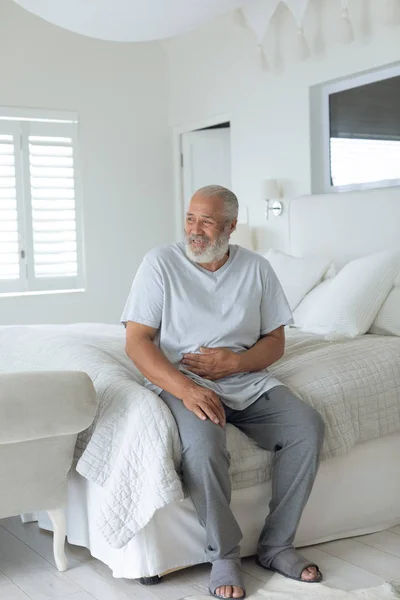 Vista Lateral Del Hombre Caucásico Mayor Sonriendo Sentado Cama Dormitorio —  Fotos de Stock