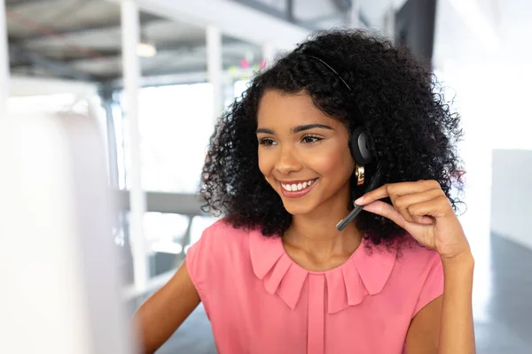 非洲裔美国女青年客户服务主管在办公室的耳机前交谈 — 图库照片