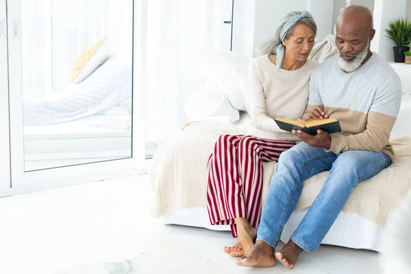 Front View Happy Senior Diverse Couple Reading Book While Sitting — Stock Photo, Image