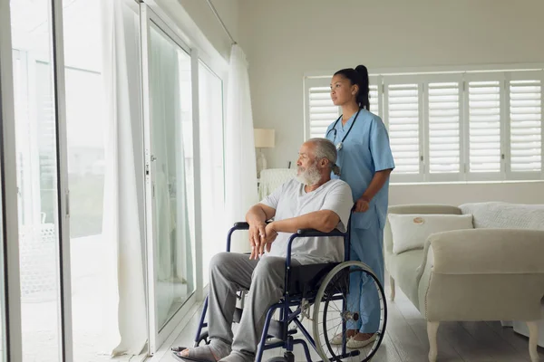 屋内車椅子の医療従事者と男性の側面図 本物のシニアリタイアライフコンセプト — ストック写真