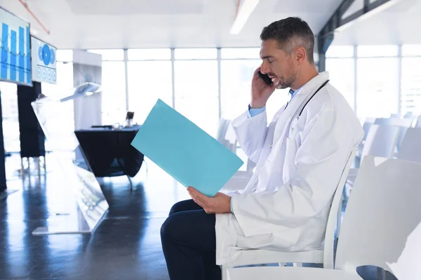 Oldalnézetből Kaukázusi Férfi Orvos Beszél Mobiltelefonon Miközben Egy Fájlt Orvosi — Stock Fotó