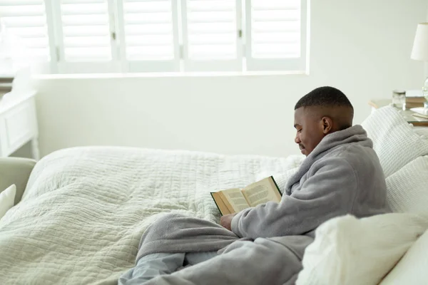 Vue Latérale Homme Afro Américain Lisant Livre Alors Était Allongé — Photo