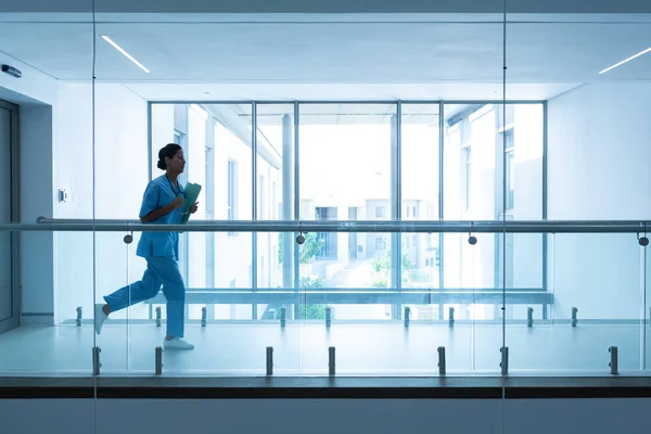 Seitenansicht Einer Gemischten Chirurgin Mit Medizinischen Berichten Die Krankenhausflur Laufen — Stockfoto