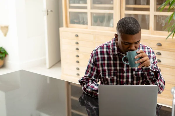 Vista Frontal Del Hombre Afroamericano Que Bebe Café Mientras Usa —  Fotos de Stock