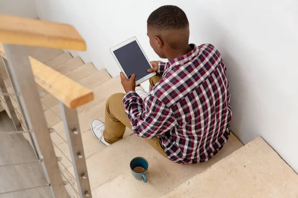 Visão Traseira Homem Afro Americano Usando Tablet Digital Enquanto Sentado — Fotografia de Stock