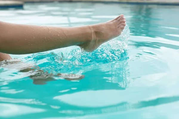 スイミングプールで水をはねる女性の低部クローズアップ — ストック写真
