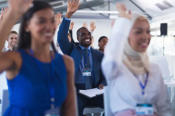 ビジネスセミナーに出席しながら手を挙げるハッピーアフリカ系アメリカ人ビジネスマンの正面図 — ストック写真