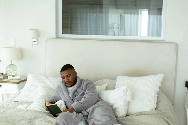 Vista Frontal Del Hombre Afroamericano Leyendo Libro Mientras Está Acostado — Foto de Stock