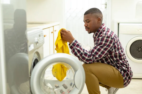 Side View African American Man Putting Clothes Washing Machine Kitchen — Stock Photo, Image