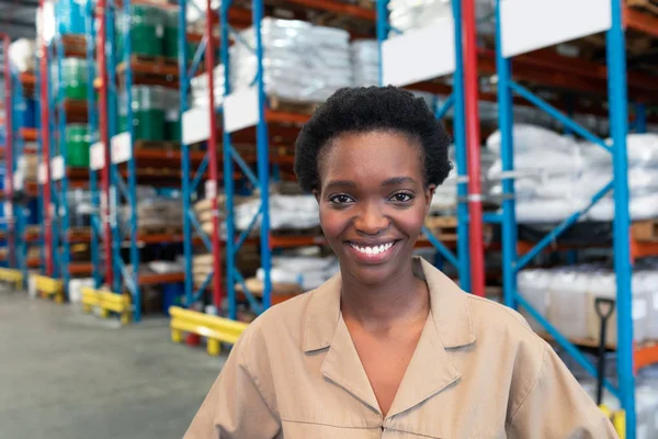 倉庫でカメラを見ている美しい若いアフリカ系アメリカ人女性スタッフの肖像画クローズアップ これは貨物輸送 物流倉庫です — ストック写真