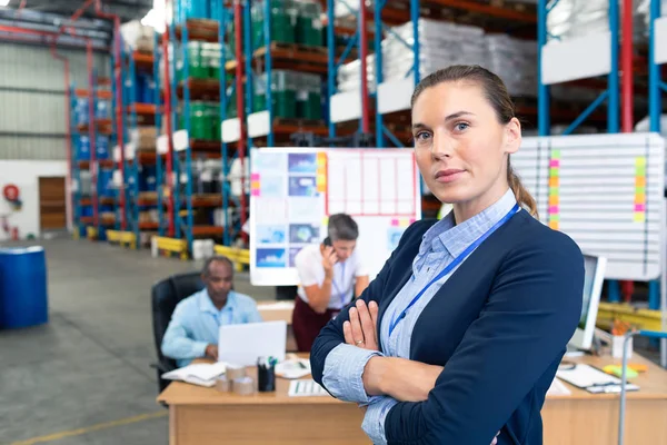 自信成熟的白种女性经理站在仓库中双臂交叉的肖像 在后台工作的多元化同事 — 图库照片