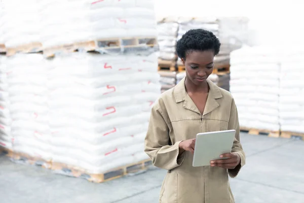 倉庫でデジタルタブレットに取り組む美しい若いアフリカ系アメリカ人女性労働者の正面図 これは貨物輸送 物流倉庫です — ストック写真