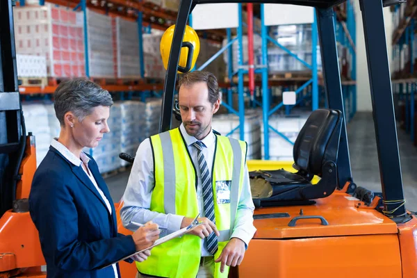 Side View Mature Caucasian Male Female Staff Discussing Clipboard Forklift — Stock Photo, Image