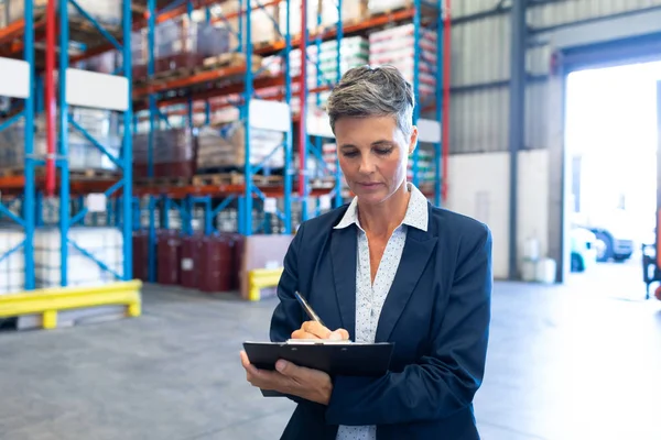 Vooraanzicht Van Mooie Rijpe Kaukasische Vrouwelijke Manager Schrijven Klembord Magazijn — Stockfoto