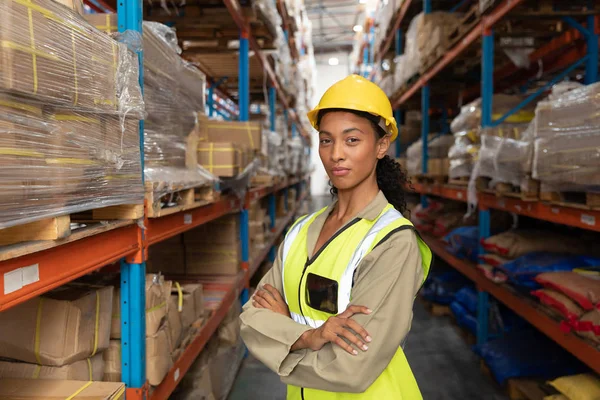 倉庫で腕を組んで立っている女性労働者の肖像 — ストック写真