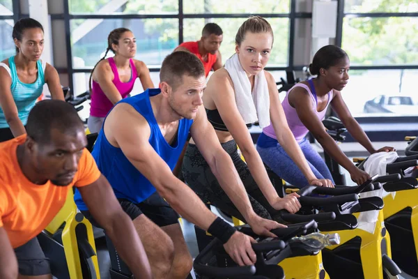 Widok Boku Zróżnicowanych Osób Ćwiczących Rowerze Treningowym Centrum Fitness Jasna — Zdjęcie stockowe