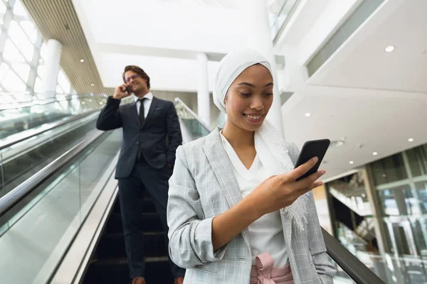 Gelukkige Zakenmensen Die Mobiele Telefoon Gebruiken Roltrap Een Modern Kantoor — Stockfoto