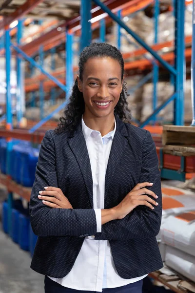 倉庫で腕を組んで立っている女性マネージャーのクローズアップ — ストック写真