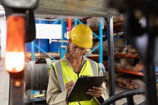 Female Staff Writing Clipboard While Sitting Forklift Warehouse — Stock Photo, Image