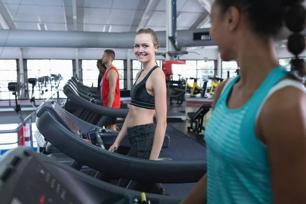 Fitness Merkezinde Koşu Bandında Egzersiz Yaparken Kadın Arkadaşıyla Etkileşime Giren — Stok fotoğraf