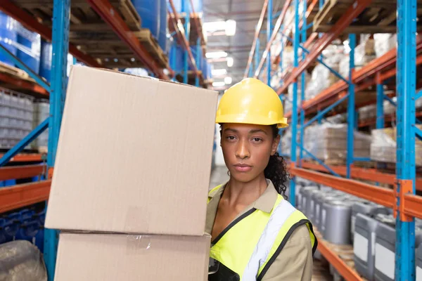 倉庫に段ボール箱を運ぶ女性職員の肖像 — ストック写真