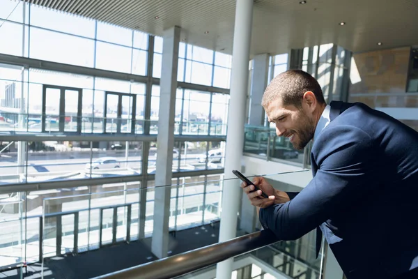 Seitenansicht Eines Jungen Kaukasischen Geschäftsmannes Der Lächelnd Auf Sein Smartphone — Stockfoto