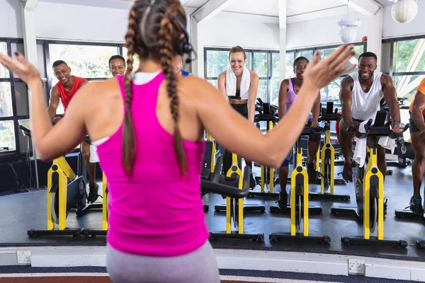 Bakifrån Kaukasisk Kvinnlig Tränare Tränar Människor Att Träna Ergometercykel Gym — Stockfoto