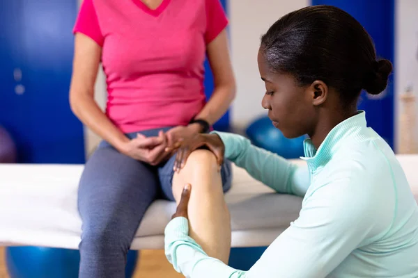 在体育中心为在职妇女提供腿部按摩的女性理疗师 — 图库照片